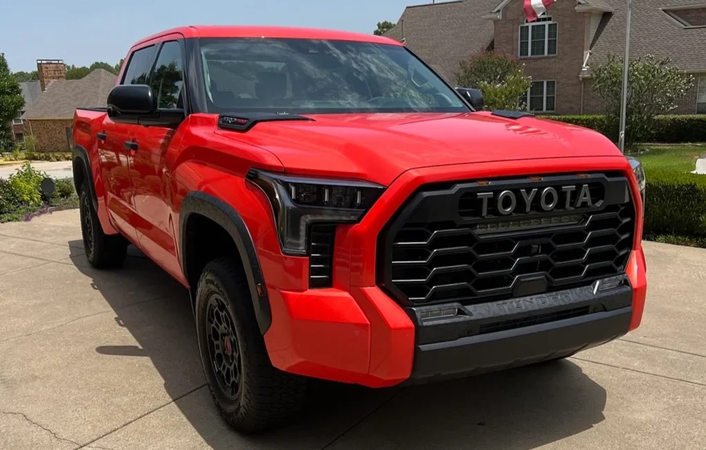 a red truck parked in a driveway, Toyota Tundra 2024